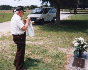 Dad playing hymns at Mom's grave